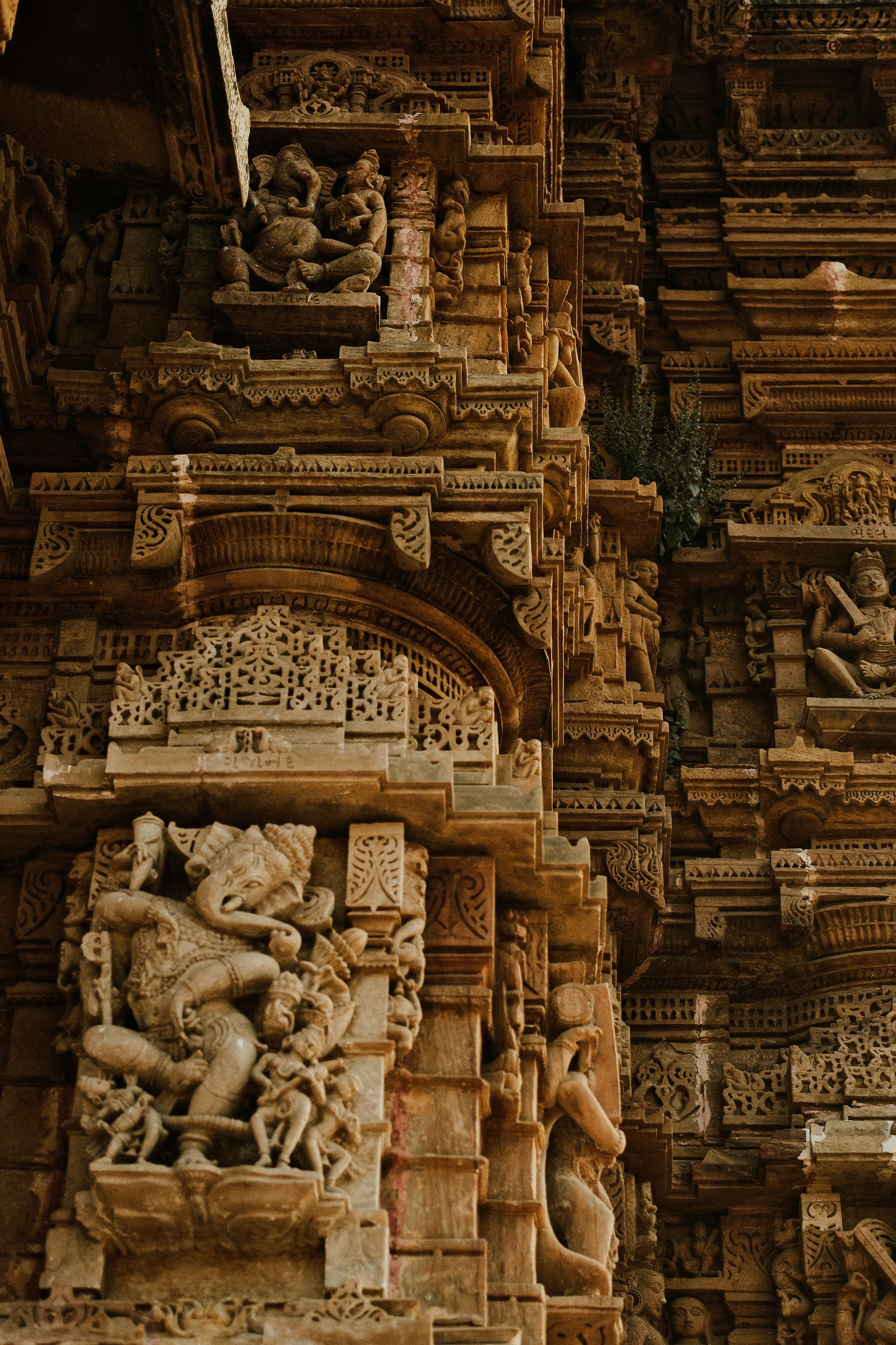 Sandstone temple wall carvings including a panel of a dancing Ganesha
